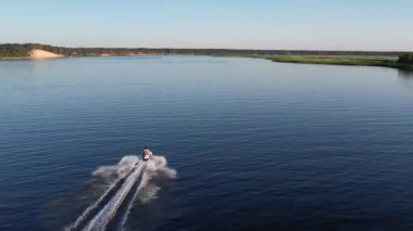 Mavi denizde yüksek hızda seyreden lüks sürat teknesinin fotokopi uzayına sahip bir hava aracı. Yelkenli yatın ve suda altın gün batımının yansıması. Okyanustaki denizcilik gemisinde boş zaman. 