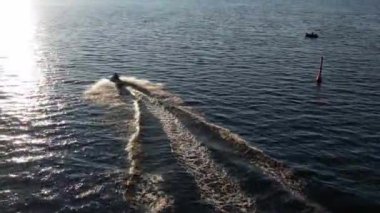 Mavi denizde yüksek hızda seyreden lüks sürat teknesinin fotokopi uzayına sahip bir hava aracı. Yelkenli yatın ve suda altın gün batımının yansıması. Okyanustaki denizcilik gemisinde boş zaman. 