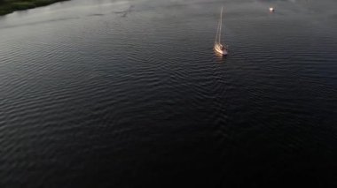 Mavi denizde yüksek hızda seyreden lüks sürat teknesinin fotokopi uzayına sahip bir hava aracı. Yelkenli yatın ve suda altın gün batımının yansıması. Okyanustaki denizcilik gemisinde boş zaman. 