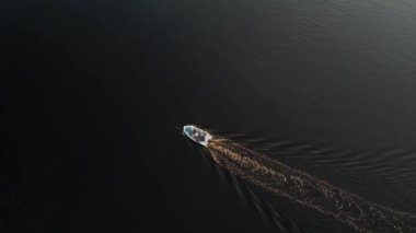 Mavi denizde yüksek hızda seyreden lüks sürat teknesinin fotokopi uzayına sahip bir hava aracı. Yelkenli yatın ve suda altın gün batımının yansıması. Okyanustaki denizcilik gemisinde boş zaman. 