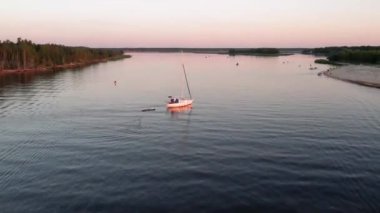 Mavi denizde yüksek hızda seyreden lüks sürat teknesinin fotokopi uzayına sahip bir hava aracı. Yelkenli yatın ve suda altın gün batımının yansıması. Okyanustaki denizcilik gemisinde boş zaman.