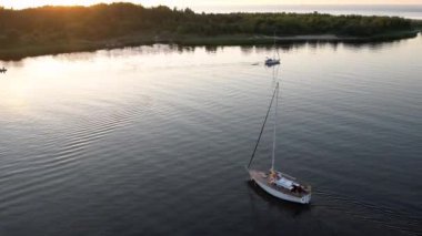 Mavi denizde yüksek hızda seyreden lüks sürat teknesinin fotokopi uzayına sahip bir hava aracı. Yelkenli yatın ve suda altın gün batımının yansıması. Okyanustaki denizcilik gemisinde boş zaman.