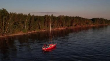 Mavi denizde yüksek hızda seyreden lüks sürat teknesinin fotokopi uzayına sahip bir hava aracı. Yelkenli yatın ve suda altın gün batımının yansıması. Okyanustaki denizcilik gemisinde boş zaman.
