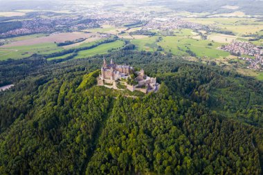 Hohenzollern Kalesi 'nin yaz aylarında Swabian Alpleri' ndeki orman tepesindeki insansız hava aracı görüntüleri. Eski Alman Burg 'unun manzaralı görüntüsü. Stuttgart civarındaki ünlü Gotik Peri Masalı