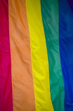 Yakın plan gökkuşağı eşcinsellik gururu bayrağı bir sokakta. Lezbiyen Biseksüel Transseksüel LGBT topluluğunun sembolü bulutlu gökyüzüne karşı rüzgarda sallanıyor. Özgürlük ve eşitlik için sosyal hareket. Boşluğu Kopyala 