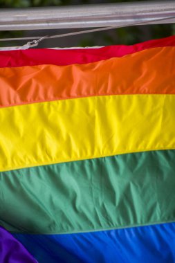 Yakın plan gökkuşağı eşcinsellik gururu bayrağı bir sokakta. Lezbiyen Biseksüel Transseksüel LGBT topluluğunun sembolü bulutlu gökyüzüne karşı rüzgarda sallanıyor. Özgürlük ve eşitlik için sosyal hareket. Boşluğu Kopyala 