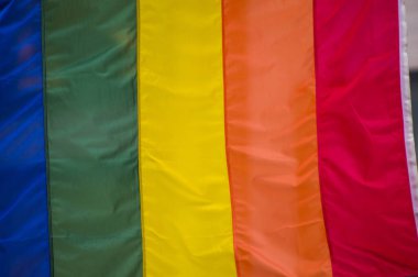 Yakın plan gökkuşağı eşcinsellik gururu bayrağı bir sokakta. Lezbiyen Biseksüel Transseksüel LGBT topluluğunun sembolü bulutlu gökyüzüne karşı rüzgarda sallanıyor. Özgürlük ve eşitlik için sosyal hareket. Boşluğu Kopyala 