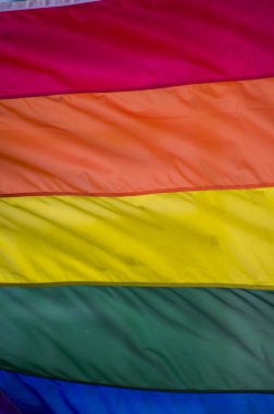 Yakın plan gökkuşağı eşcinsellik gururu bayrağı bir sokakta. Lezbiyen Biseksüel Transseksüel LGBT topluluğunun sembolü bulutlu gökyüzüne karşı rüzgarda sallanıyor. Özgürlük ve eşitlik için sosyal hareket. Boşluğu Kopyala 