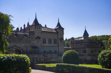 Lihtenştayn Şatosu 'nun ya da Schloss' un yazın Swabian Alpleri 'ndeki ormanlık kayalıklardaki fotoğrafı. Gökyüzünde Gotik diriliş tarzında romantik masal sarayının mevsimsel manzarası. Avrupa 'nın ünlü simgesi