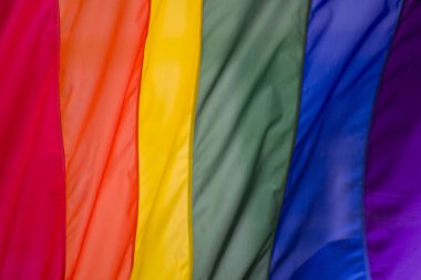 Yakın plan gökkuşağı eşcinsellik gururu bayrağı bir sokakta. Lezbiyen Biseksüel Transseksüel LGBT topluluğunun sembolü bulutlu gökyüzüne karşı rüzgarda sallanıyor. Özgürlük ve eşitlik için sosyal hareket. Boşluğu Kopyala 