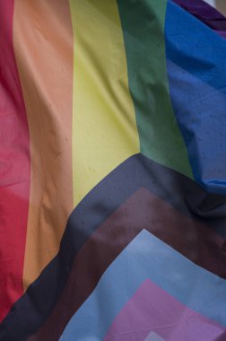 Yakın plan gökkuşağı eşcinsellik gururu bayrağı bir sokakta. Lezbiyen Biseksüel Transseksüel LGBT topluluğunun sembolü bulutlu gökyüzüne karşı rüzgarda sallanıyor. Özgürlük ve eşitlik için sosyal hareket. Boşluğu Kopyala 