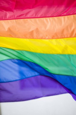 Yakın plan gökkuşağı eşcinsellik gururu bayrağı bir sokakta. Lezbiyen Biseksüel Transseksüel LGBT topluluğunun sembolü bulutlu gökyüzüne karşı rüzgarda sallanıyor. Özgürlük ve eşitlik için sosyal hareket. Boşluğu Kopyala 