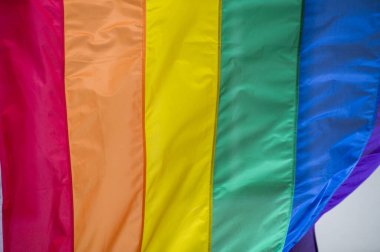 Yakın plan gökkuşağı eşcinsellik gururu bayrağı bir sokakta. Lezbiyen Biseksüel Transseksüel LGBT topluluğunun sembolü bulutlu gökyüzüne karşı rüzgarda sallanıyor. Özgürlük ve eşitlik için sosyal hareket. Boşluğu Kopyala 