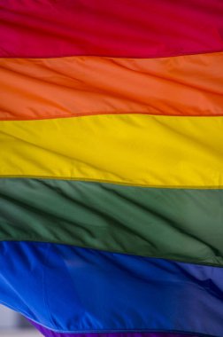 Yakın plan gökkuşağı eşcinsellik gururu bayrağı bir sokakta. Lezbiyen Biseksüel Transseksüel LGBT topluluğunun sembolü bulutlu gökyüzüne karşı rüzgarda sallanıyor. Özgürlük ve eşitlik için sosyal hareket. Boşluğu Kopyala 