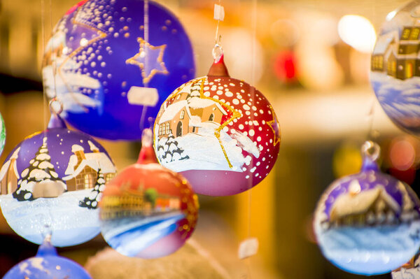 Киоски Advent Bazaar со стеклянными, деревянными, керамическими сувенирами в магазине. Закрытие праздничных украшений для елки на ночном рынке зимней улицы в новогодние праздники. Иллюминированный выставочный киоск