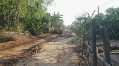 Kampong - Kamboçya - 03 - 12 - 2019: Köyde yeni bir yol inşa eden küçük bir buldozer manzarası 