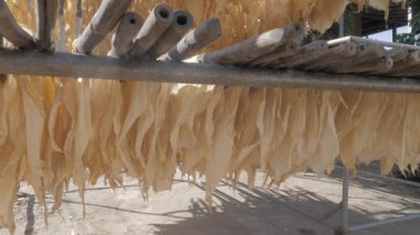 Güneşin altında kızarana kadar bambu çubuklarıyla cilt tofusu yakın.