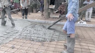Kampong - Kamboçya - 04-09 - 2018; yol inşaatı için betonun yakınına dökülüyor