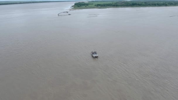メコン川を渡る乗客やオートバイと小さなフェリーの空飛ぶショット — ストック動画