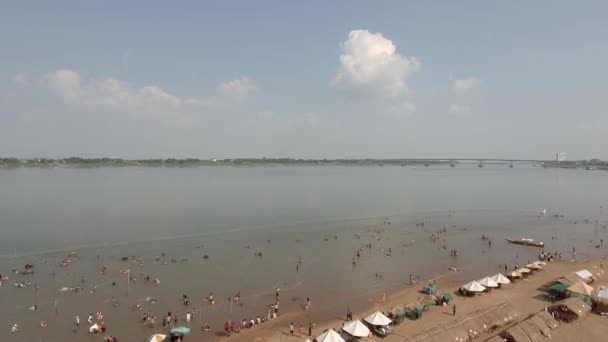砂浜に木製のバンガローが広がる中 大勢の人々の無人偵察機の映像が集まって泳いでいます — ストック動画