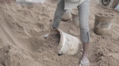 Kum bir kova içine koymak için bir kürek kullanarak (yakın)