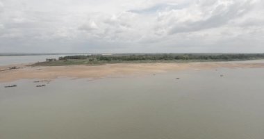 Mekong Nehri 'ndeki küçük balıkçı teknelerinin hava görüntüsü. Arkaplan olarak küçük ada boyunca kumsallar
