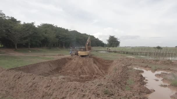 Kampong カンボジア 2019 オープンフィールドで小さなトラックに地球をロード掘削機のバックビュー — ストック動画