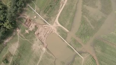 Kırsal bölgedeki küçük bir nehrin üzerindeki bambu köprüsüne bakıyorum.