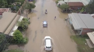 Battambang - Kamboçya - 10 - 08 - 2020: sel basmış bir sokaktan geçen araçların hava desteği