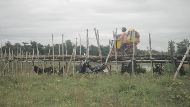 Kampong カンボジア 2019 竹の橋を渡りながら服の山を運ぶ売り手 — ストック動画