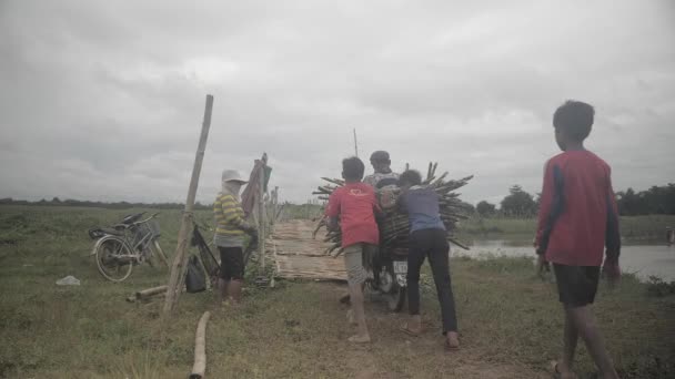 柬埔寨磅 柬埔寨 2019 男孩们帮助一个男人把她的摩托车载着竹子推上竹桥 — 图库视频影像