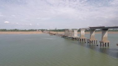 aerial static view of steel pipe piles being drilled into the riverbed for a bridge foundation. ( Bridge under construction)