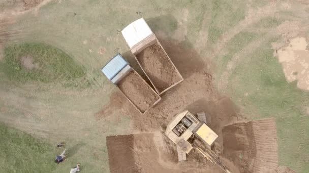 Drone Shot Excavator Loading Earth Two Trucks Open Field — Stockvideo