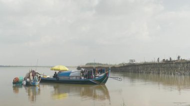 Kampong Cham - Kamboçya - 07 - 10 - 2019: nehrin kenarında geleneksel balıkçı tekneleri. Arka planda Bambu köprüsü  