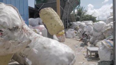 Phnom Penh - Kamboçya - 03 -12- 2022 - İşçi plastik şişeleri büyük poşetlere ayırdı