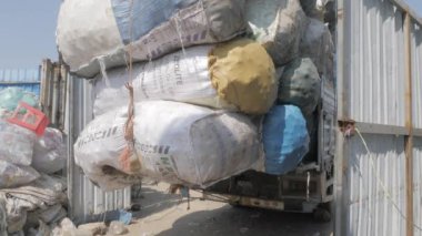 Phnom Penh - Kamboçya - 03 -12- 2022 - plastik şişeleri büyük torbalara doldurulmuş küçük bir kamyonun arka görüntüsü