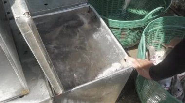 Phnom Penh - Kamboçya - 03 - 29 - 2022 - bir satıcının kapanışı küçük metal konteynıra balıkları koydu