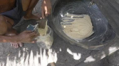 Bir çiftçinin yanına küçük plastik kutunun içine palmiye şekerinin hamurunu koy. 