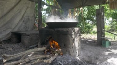 Geleneksel şeker avuçlayıcıları. Açık ahşap ateşte vok pişirme. İçinde palmiye şekeri pişiyor.. 