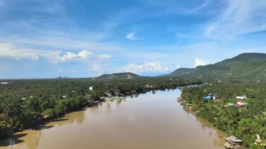 Büyük bir nehirden geriye doğru uçmak. Etrafı güzel, lüks bir doğayla çevrili. Arkaplan olarak dağlar