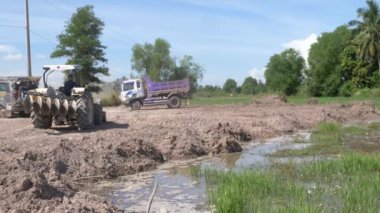 Kampot  - Cambodia - 07 -09- 2021 :  Small truck leaving from the site with another one  come to unload earth in preparation for the construction and expansion of housing