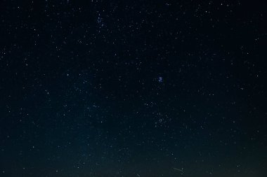 Karanlık gece. Parlayan yıldızlarla kaplı temiz bir gökyüzü. Çerçevenin ortasında Ülker takımyıldızını görebilirsiniz..