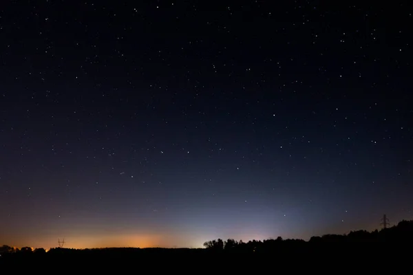 Night, dark sky illuminated by starlight. Among the many stars, you can see the constellation called the big chariot.