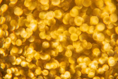 Oval sarı nesnelerden yapılmış doku. Etki, simli yüzeyi odaklanmadan makro ölçekte fotoğraflayarak elde edildi..