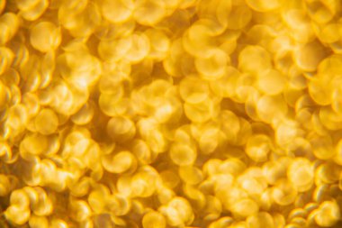 Oval sarı nesnelerden yapılmış doku. Etki, simli yüzeyi odaklanmadan makro ölçekte fotoğraflayarak elde edildi..