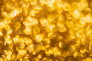 Oval sarı nesnelerden yapılmış doku. Etki, simli yüzeyi odaklanmadan makro ölçekte fotoğraflayarak elde edildi..