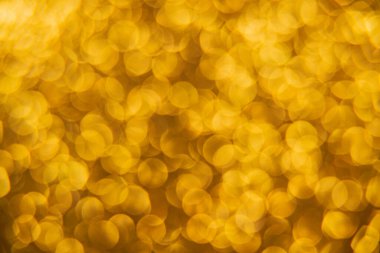 Oval sarı nesnelerden yapılmış doku. Etki, simli yüzeyi odaklanmadan makro ölçekte fotoğraflayarak elde edildi..