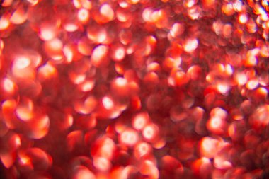 Doku oval kırmızı nesnelerden yaratıldı. Etki, simli yüzeyi odaklanmadan makro ölçekte fotoğraflayarak elde edildi..