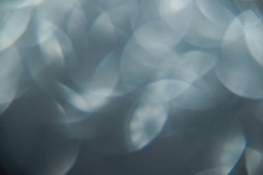 Doku oval gri nesnelerden yaratıldı. Etki, simli yüzeyi odaklanmadan makro ölçekte fotoğraflayarak elde edildi..