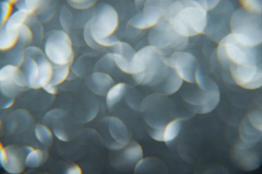 Doku oval gri nesnelerden yaratıldı. Etki, simli yüzeyi odaklanmadan makro ölçekte fotoğraflayarak elde edildi..